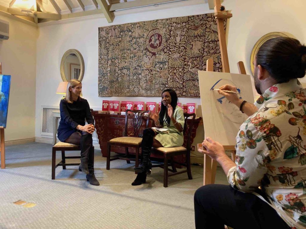 Brad Kenny painting a portrait of Dana Thomas, sustainability editor of Vogue magazine while she is being interviewed by artist hana