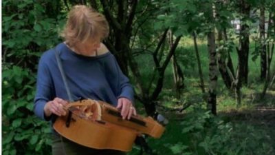 Sensing Trees: Stevie Wishart playing hurdy gurdy in a forest